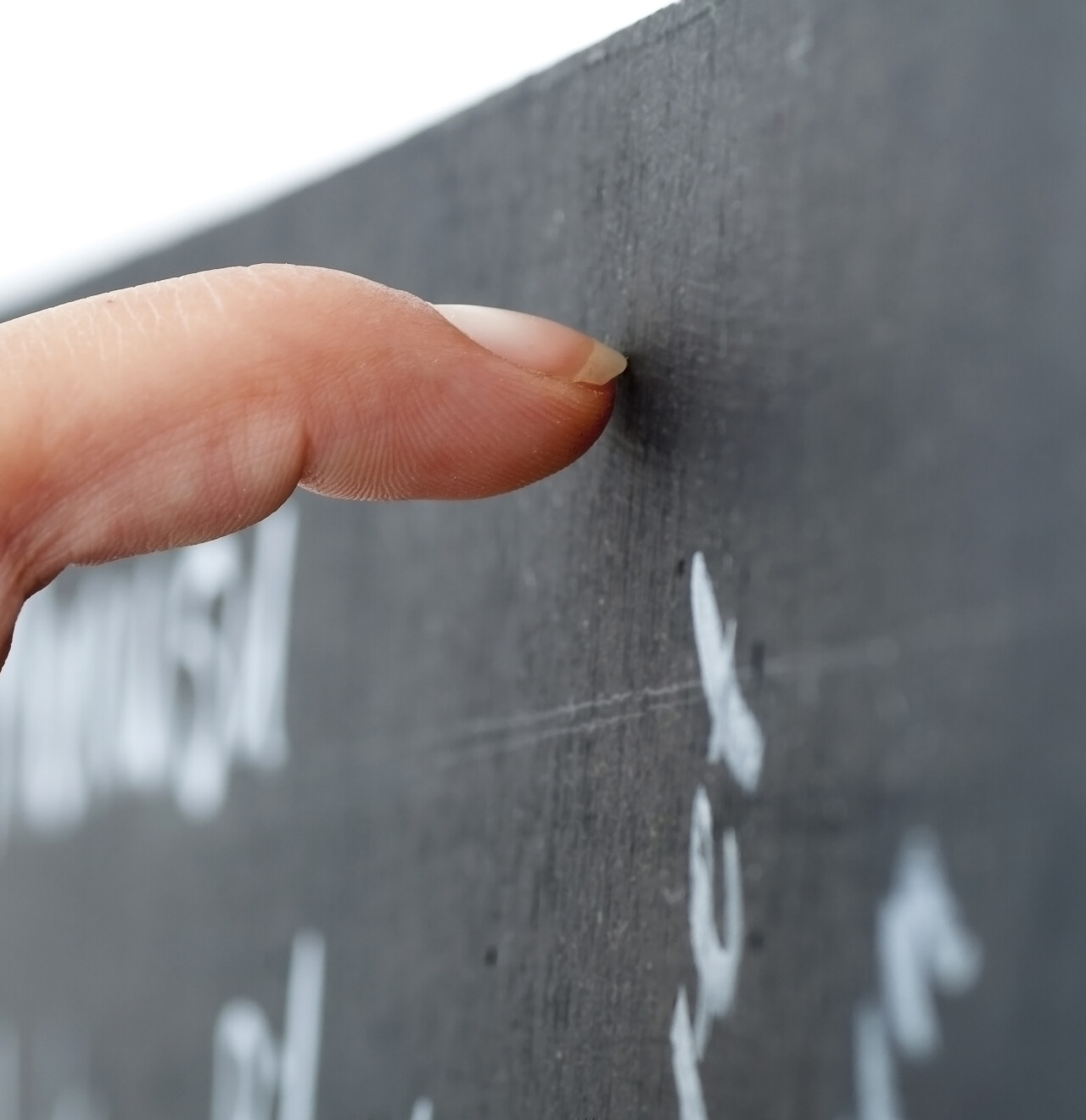 Vinger wijst naar woord op schoolbord,symbool voor uitleg over misofonie en sterke emotionele reacties op geluid.